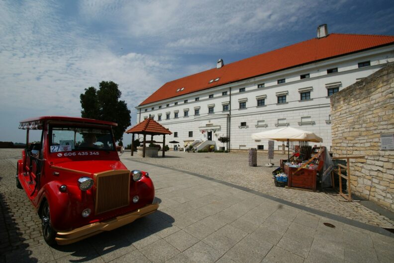 a red bus parked in front of a white building